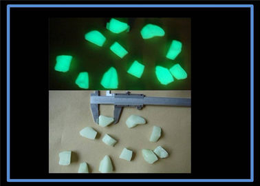 Incandescenza gialla dei materiali luminescenti di colore verde nelle pietre scure del giardino
